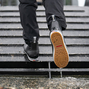 Person walking up steps in the rain showing shoe outsole